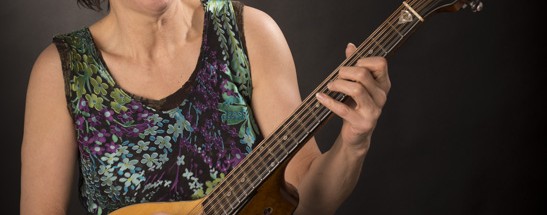 Publicity shot of Carol Coronis playing the cittern